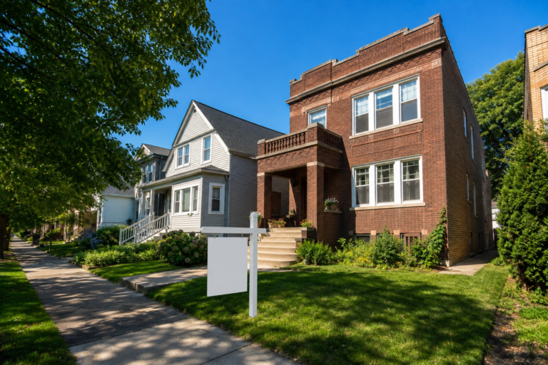 A Chicago residential street with a brick two-flat and a house on a sunny morning