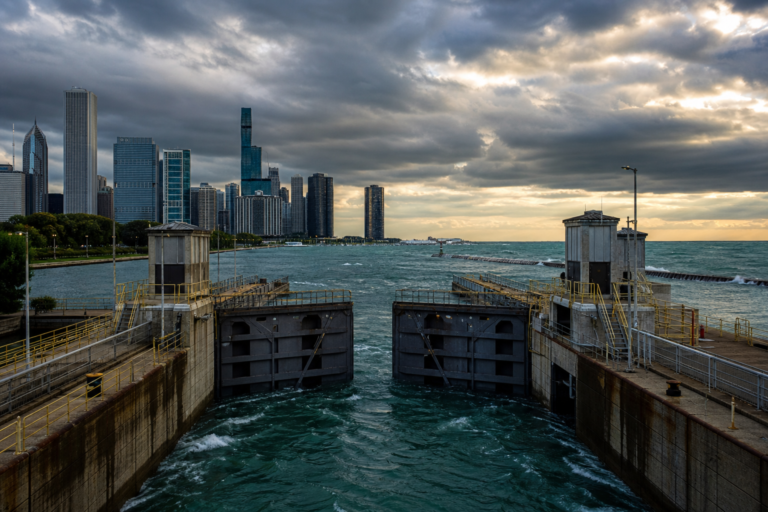 Lock gates and controlling works where the Chicago River meets Lake Michigan under a stormy sky