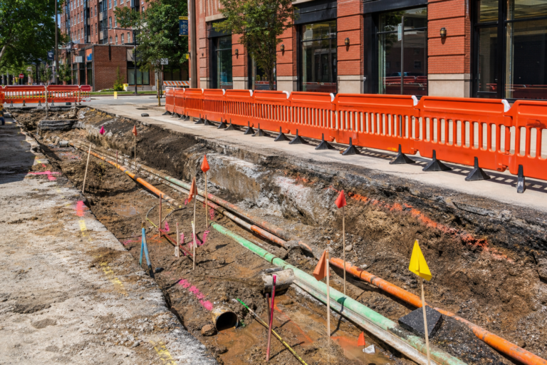 Open utility trench with locate flags on a Chicago street
