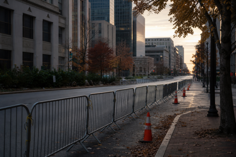 Metal barricades and traffic cones on an empty downtown street at dawn