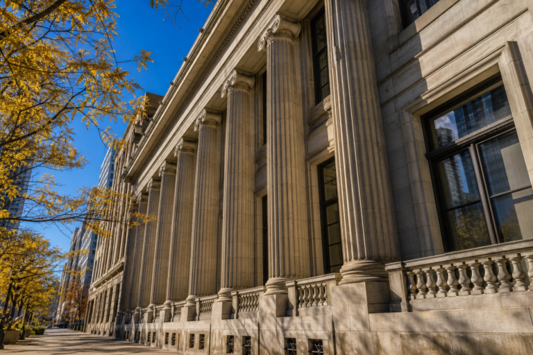 The tall stone columns of a government building in Chicago's Loop on a bright, clear autumn day