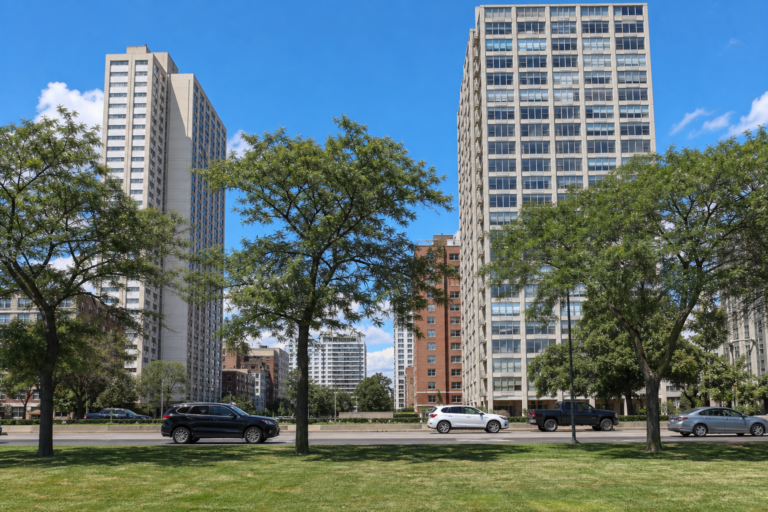 Mid-century high-rise residential towers along a tree-lined lakefront drive on Chicago's North Side